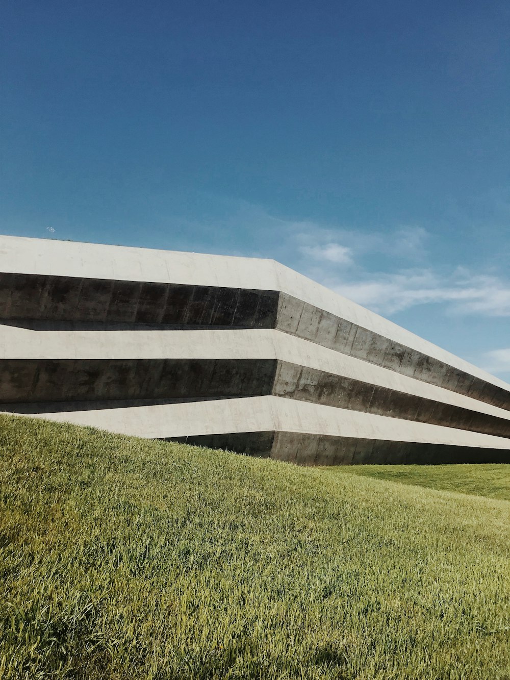 a large building sitting on top of a lush green field