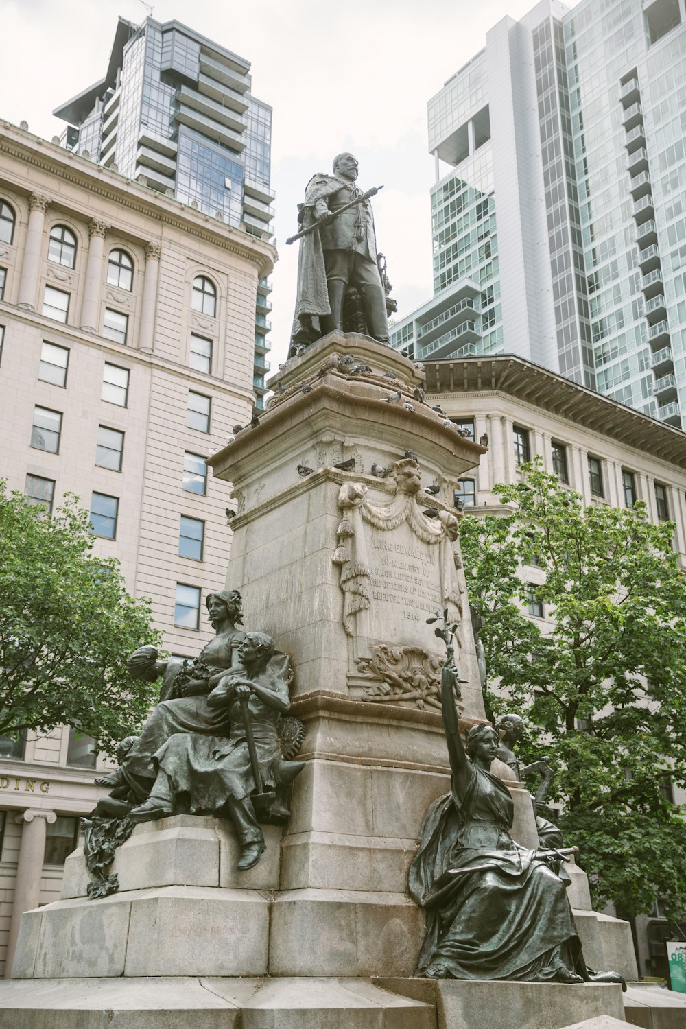 Hombre sosteniendo la estatua de la espada cerca del edificio blanco de gran altura durante el día