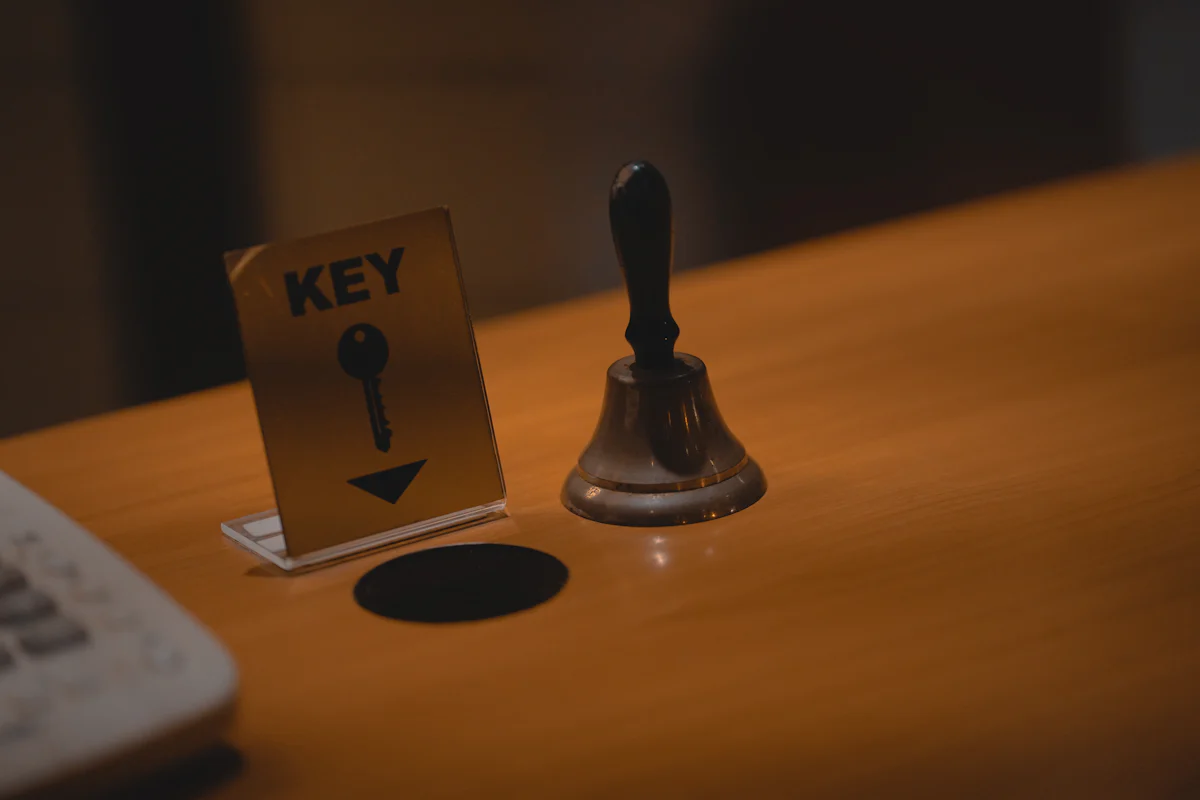 A service bell and a KEY sign on a wooden reception counter