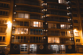 Modern apartment facade with warm lights in Marrakech evening.