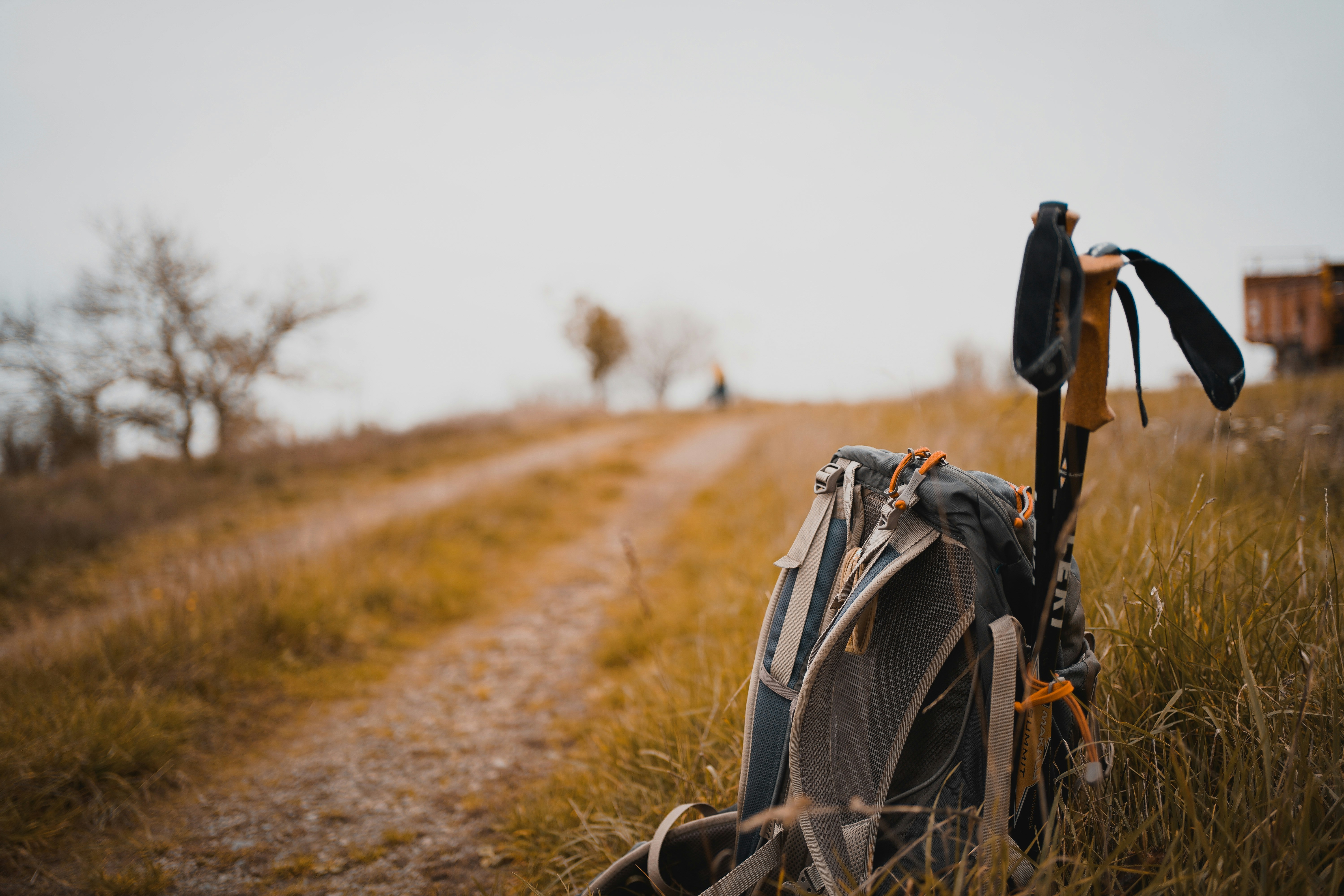 Trekking poles leaning against a backpack on a mountain summit
