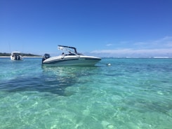 Speedboat cutting through crystal-clear turquoise water on a sunny day