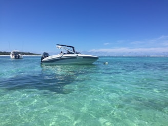 A sleek speedboat cutting through the turquoise waters of the Maldives under a bright sunny sky.