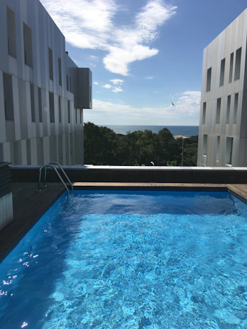 A sparkling clean pool reflecting the Miami skyline under a bright blue sky.