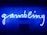 A bright blue neon sign spells out the word 'gambling' in cursive script. The background features a textured wall covered in domino tiles, also illuminated by the blue light, creating a vivid and visually striking scene.
