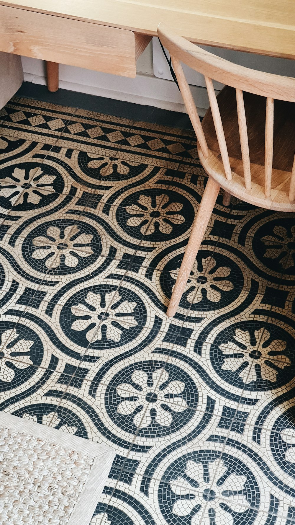 brown wooden chair on gray and black floral area rug