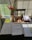 Close-up of office desk with books, paper, pens, and a laptop in natural light.