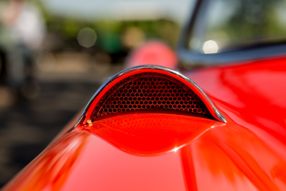selective focus photography of red vehicle's hood