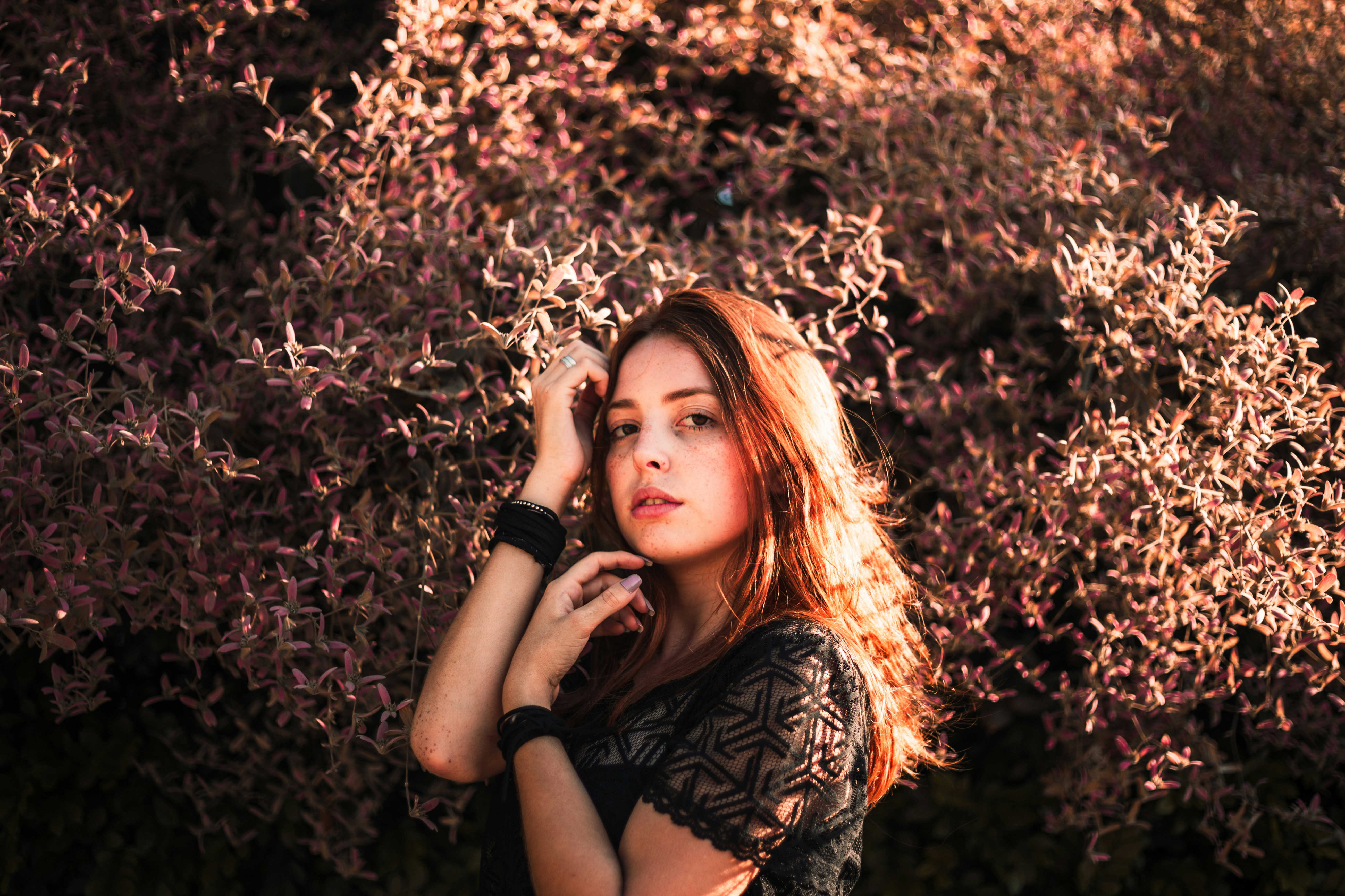 昼間に緑の植物のそばに立っている女性のセレクティブ フォーカス写真