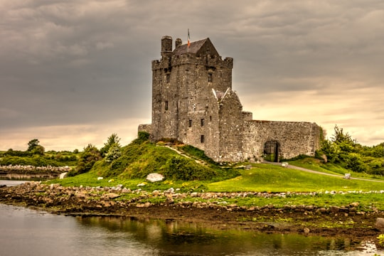 view photography of gray castle on island in Dunguaire Castle Ireland