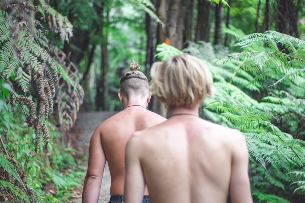 two persons walking on dirt road