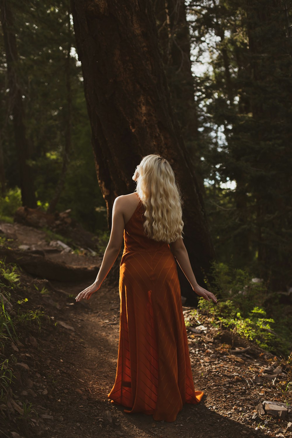 woman in brown sleeveless dress standing outdoors