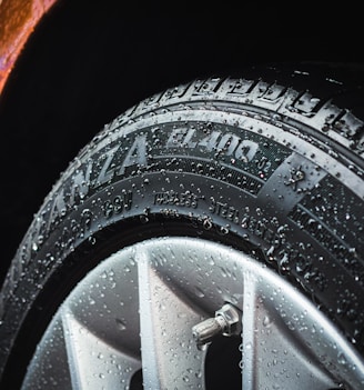 shallow focus photography of silver car wheel and car tire