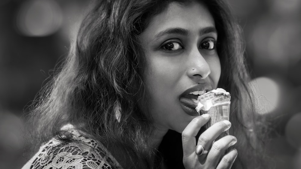 grayscale photo of woman eating ice-cream