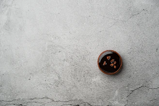 A rich chocolate tart with a glossy finish, garnished with a sprinkle of powdered sugar.