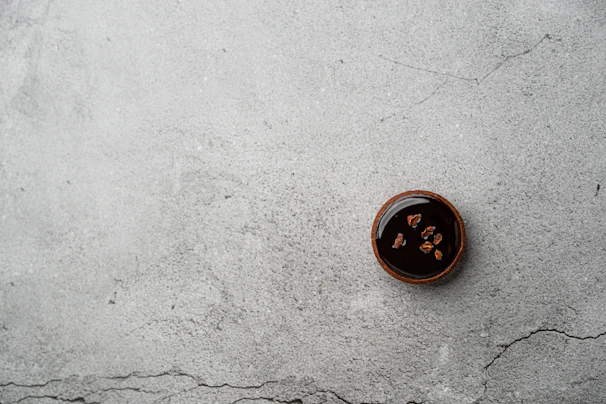 A rich chocolate tart with a glossy finish, garnished with a sprinkle of powdered sugar.