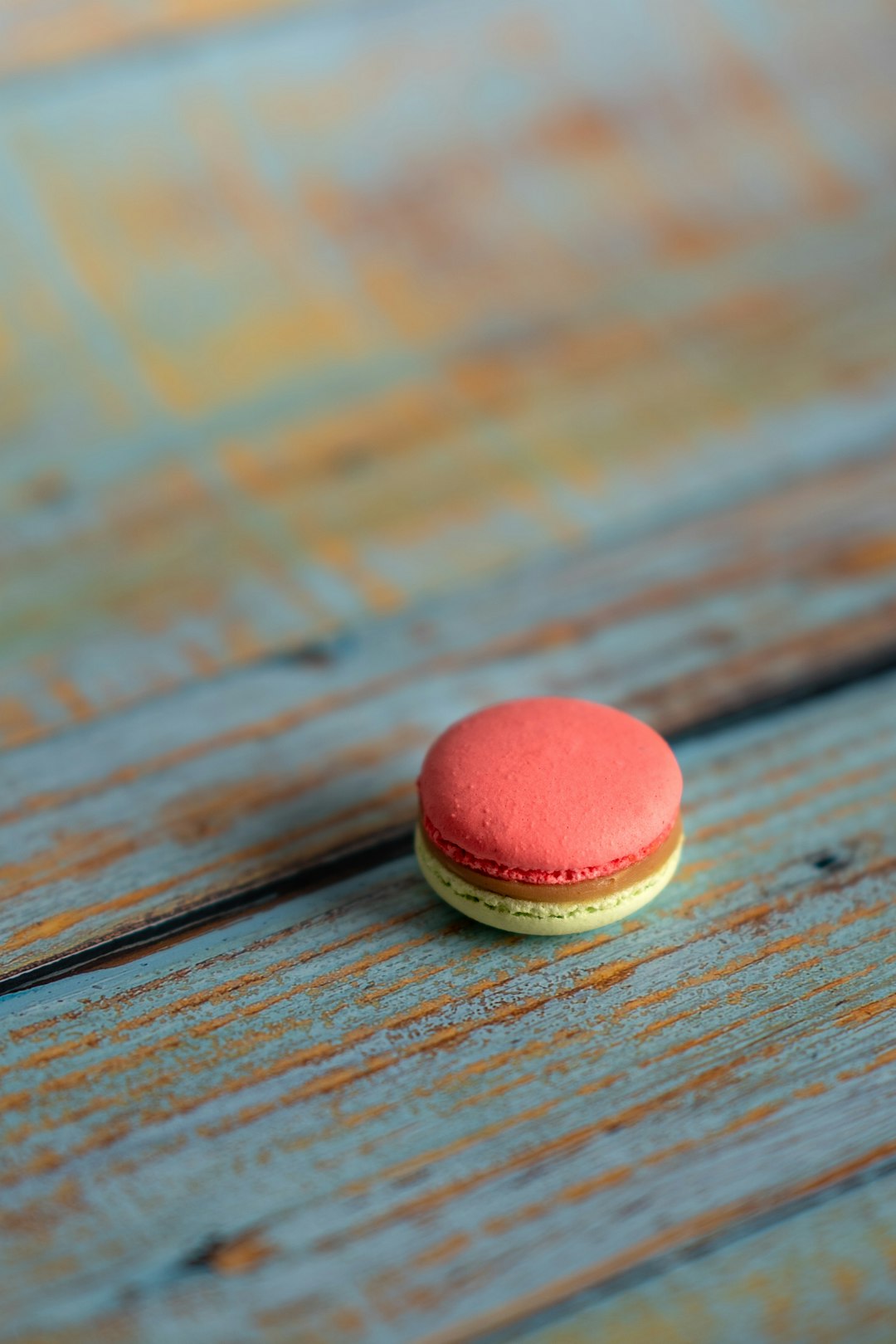 selective focus photography of French macaroon on brown surface