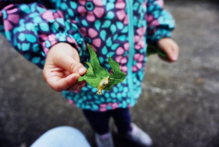 Brightly colored kids wearing playful snail-themed wearable accessories outdoors.