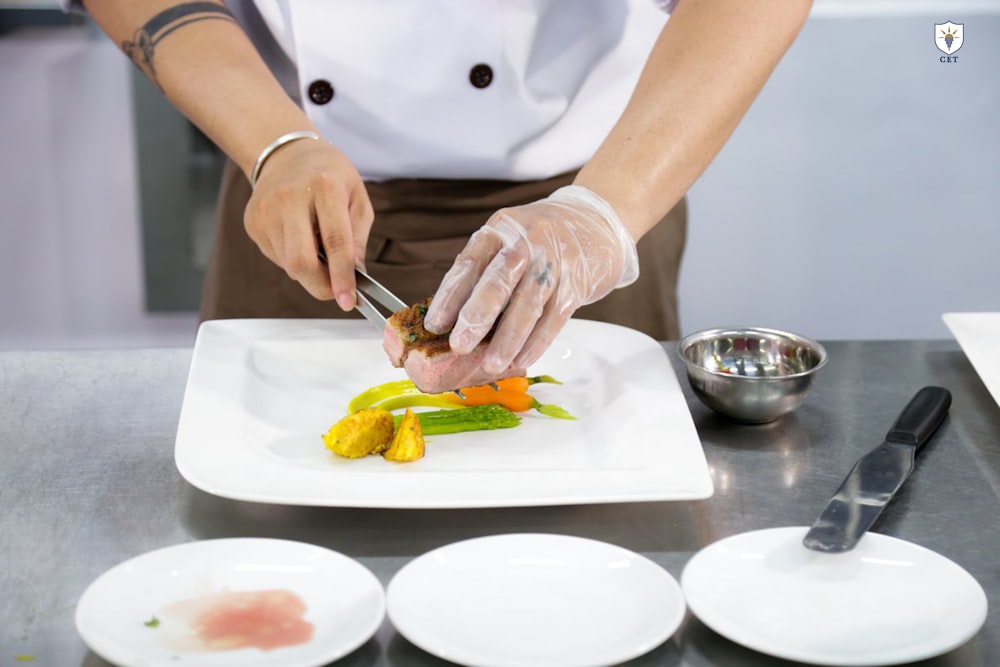 person holding gray tong preparing dish