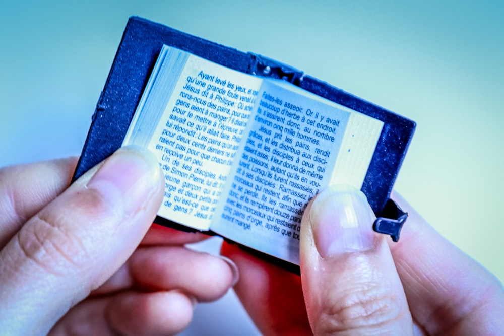 person holding mini bible