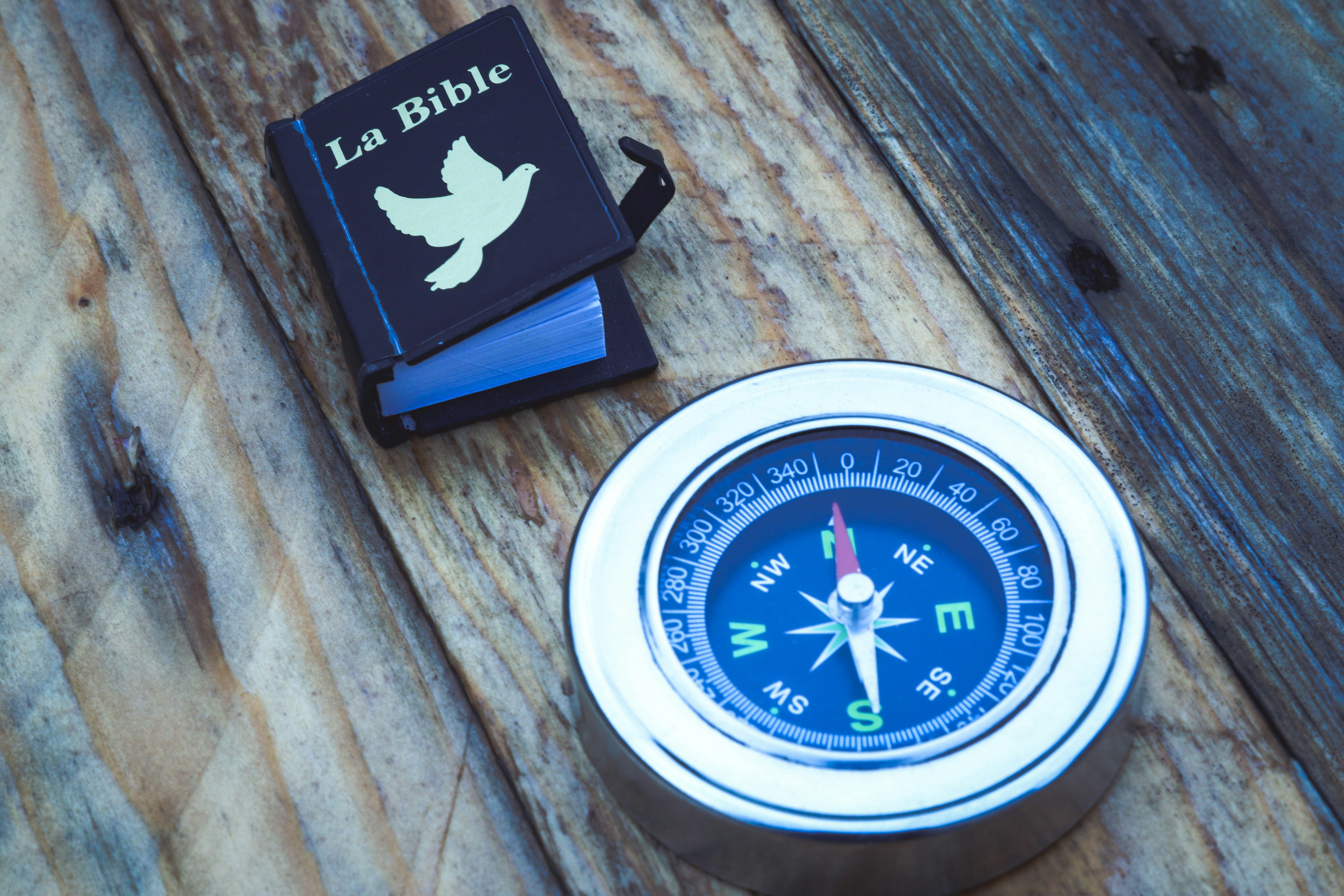 open Bible next to a compass - faith-based life coach