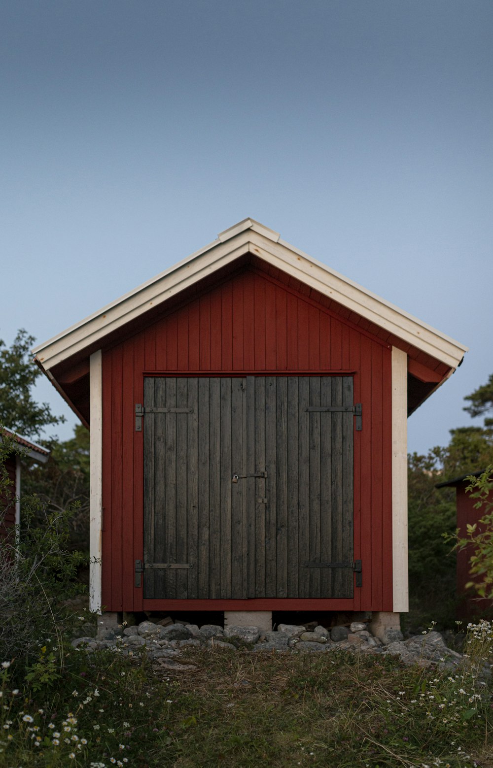 Casa de madera roja cerca del árbol
