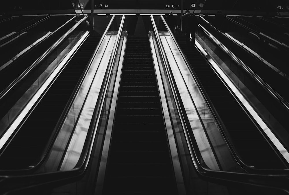 grayscale photography of escalators