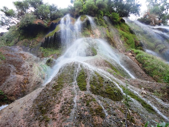 waterfalls surrounded with tall and green trees during daytime in Lorestan Province Iran