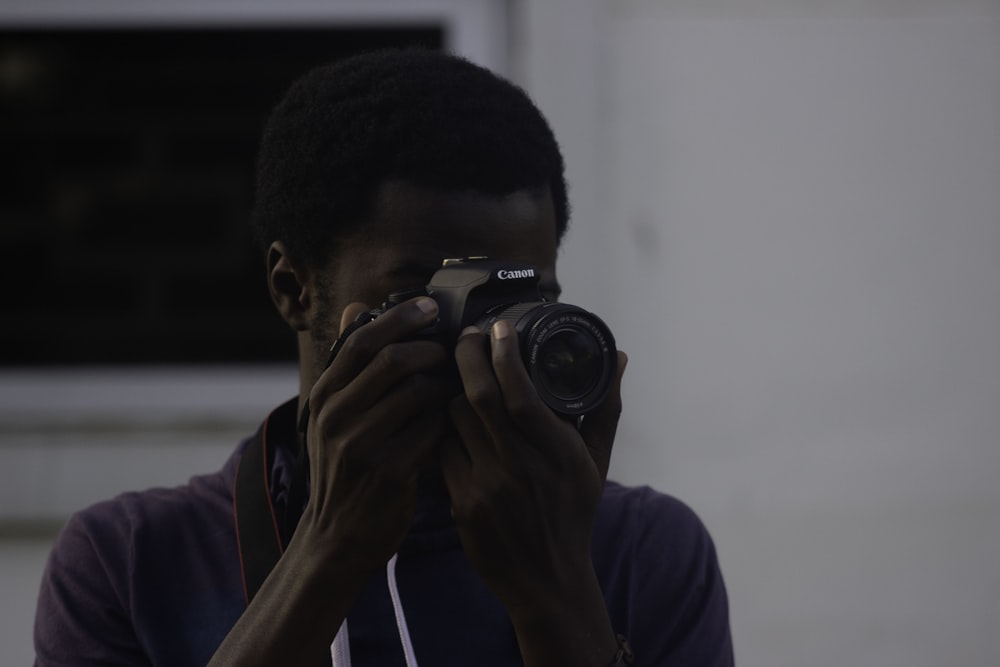 man using Canon DSLR camera