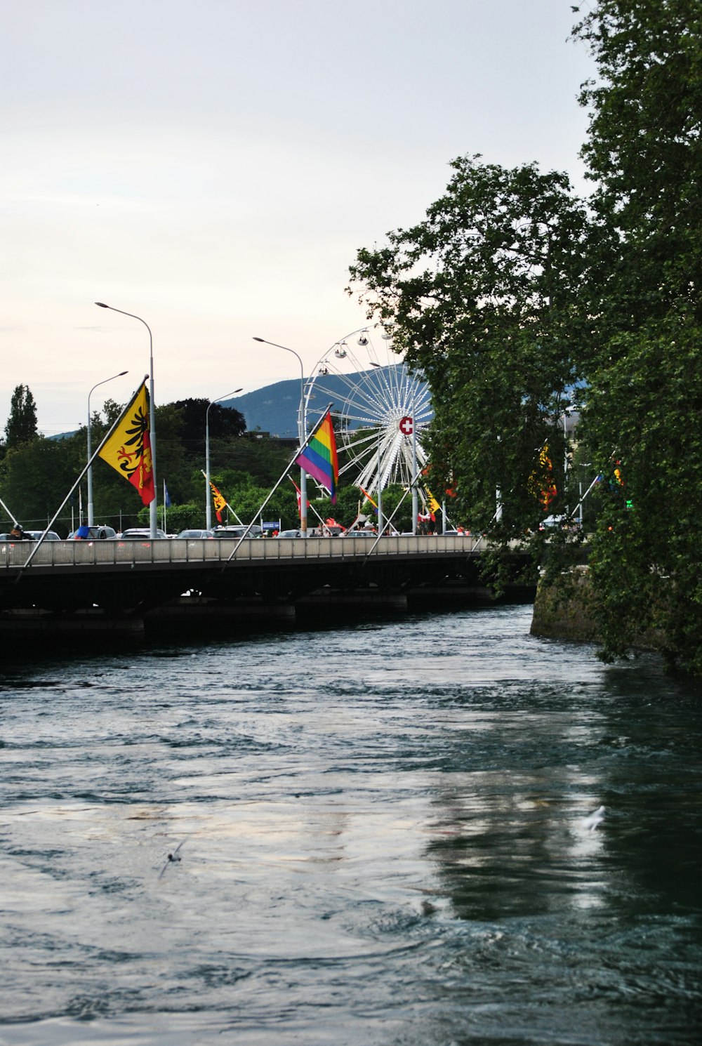 bridge with flags under white sky