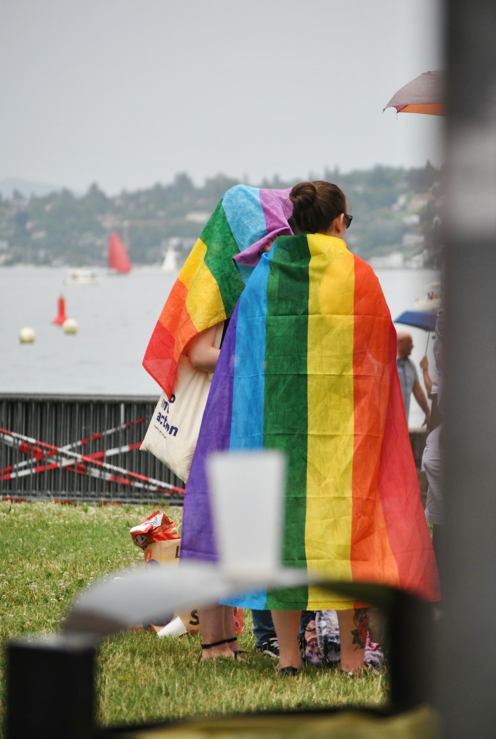 two girls with rainbow flag on back during daytime