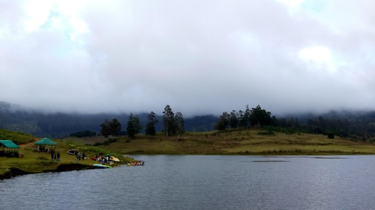 people camping beside body of water during daytime in Kodaikanal India