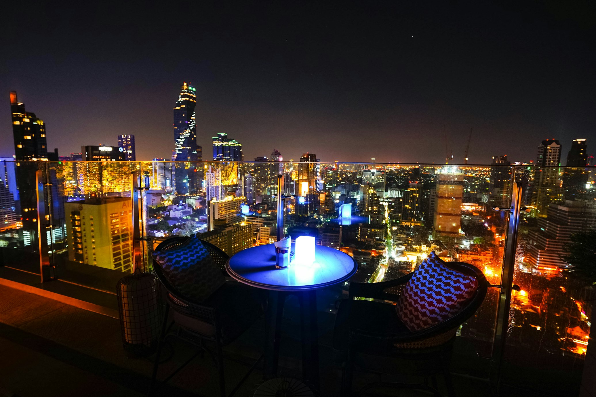 Candlelit rooftop dinner table with city skyline in background