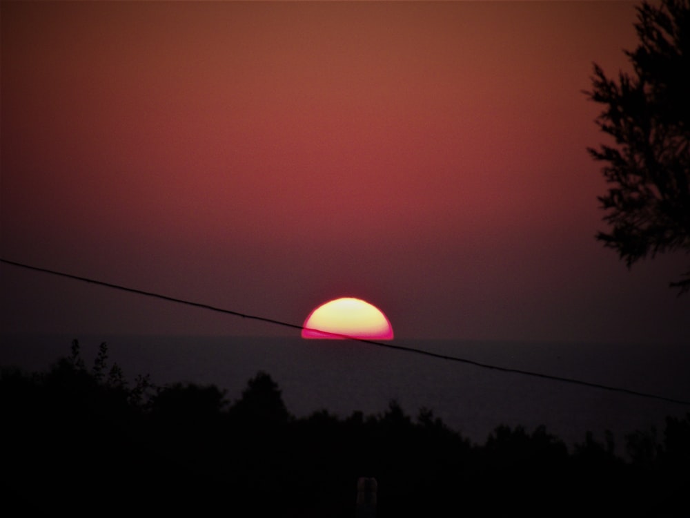 the sun is setting over a body of water