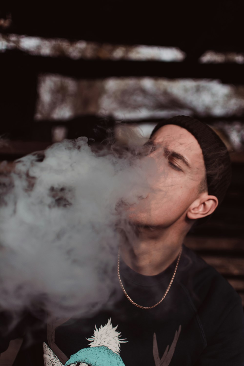 man in black crew-neck top smoking outdoors