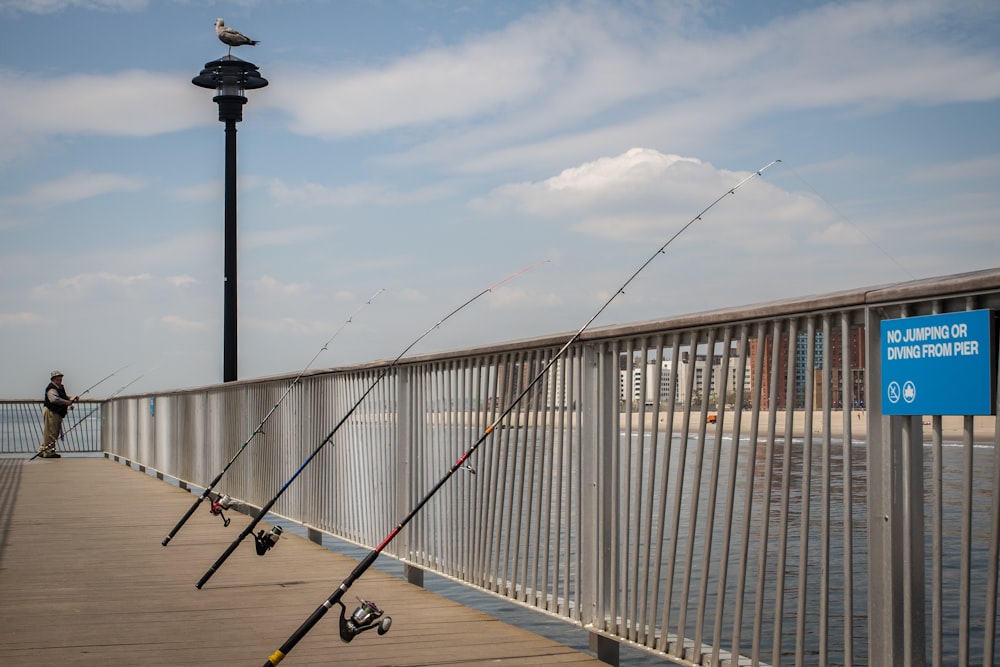 three fishing rods leaning on metal rainings