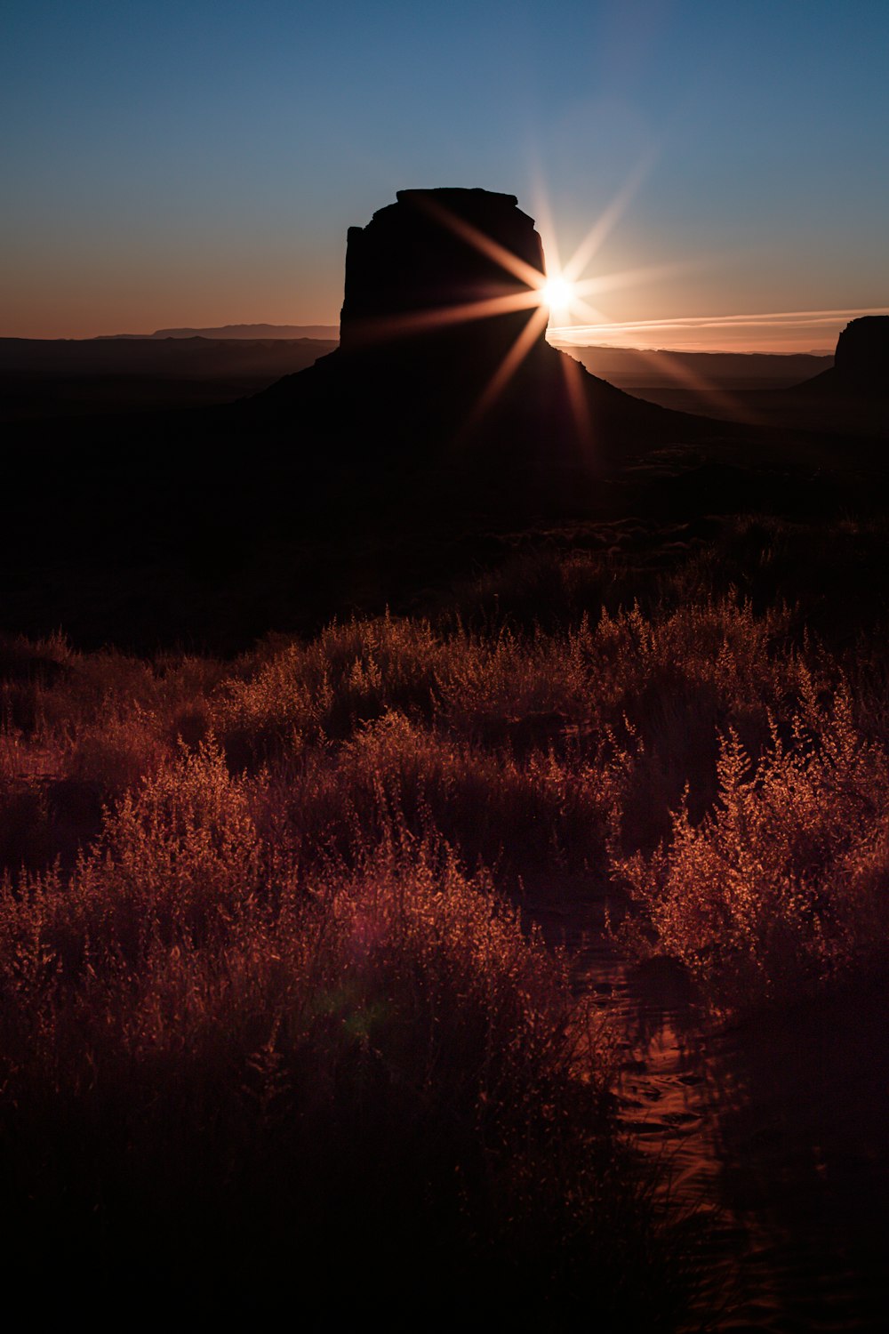 o sol está se pondo sobre uma montanha no deserto