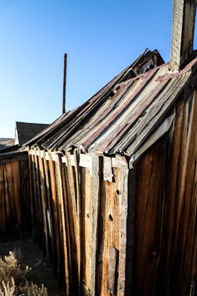 A rustic ag structure with heavy timber accents standing strong against a clear blue sky.