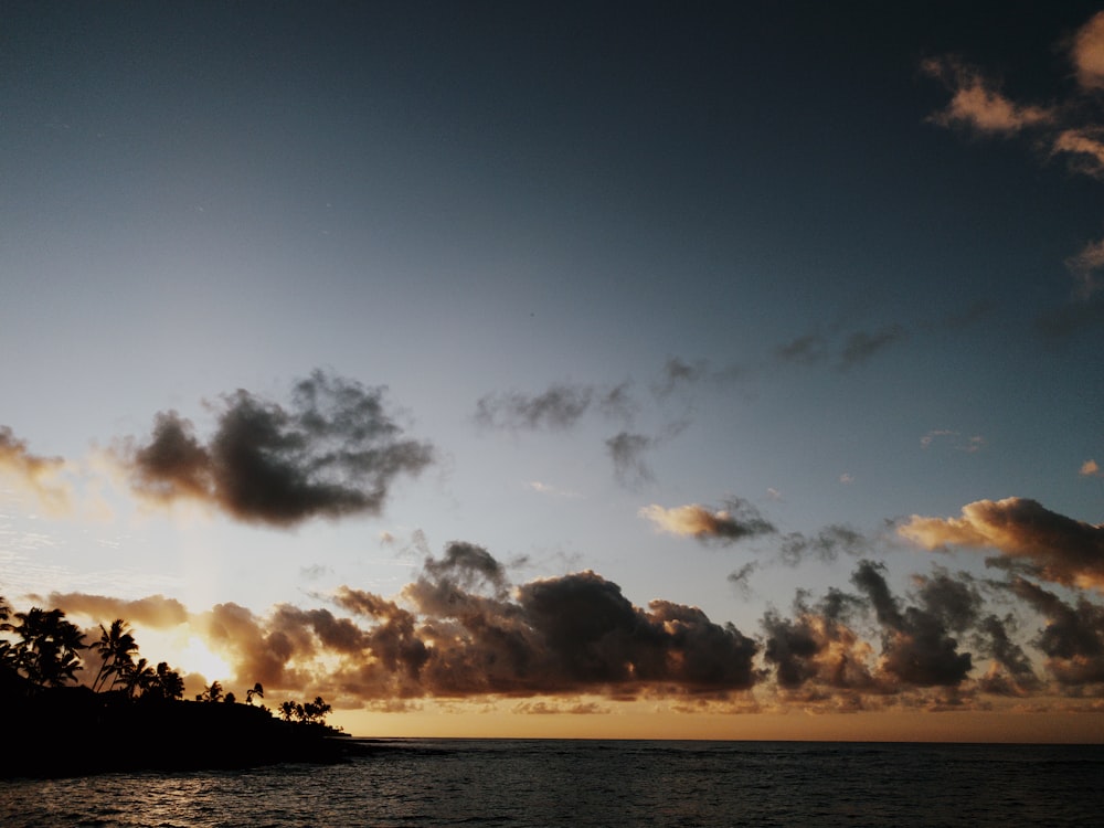 gray clouds and silhouette of island