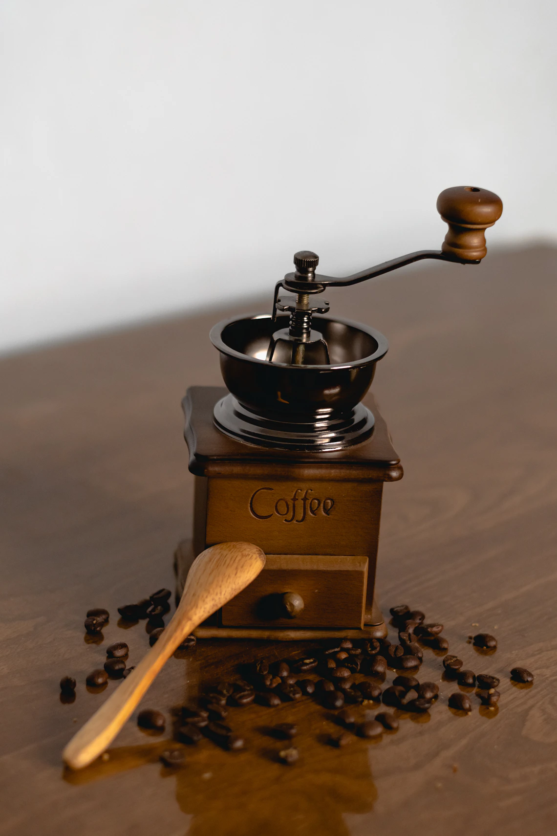 Premium coffee grinder with roasted coffee beans in a warm coffee setting