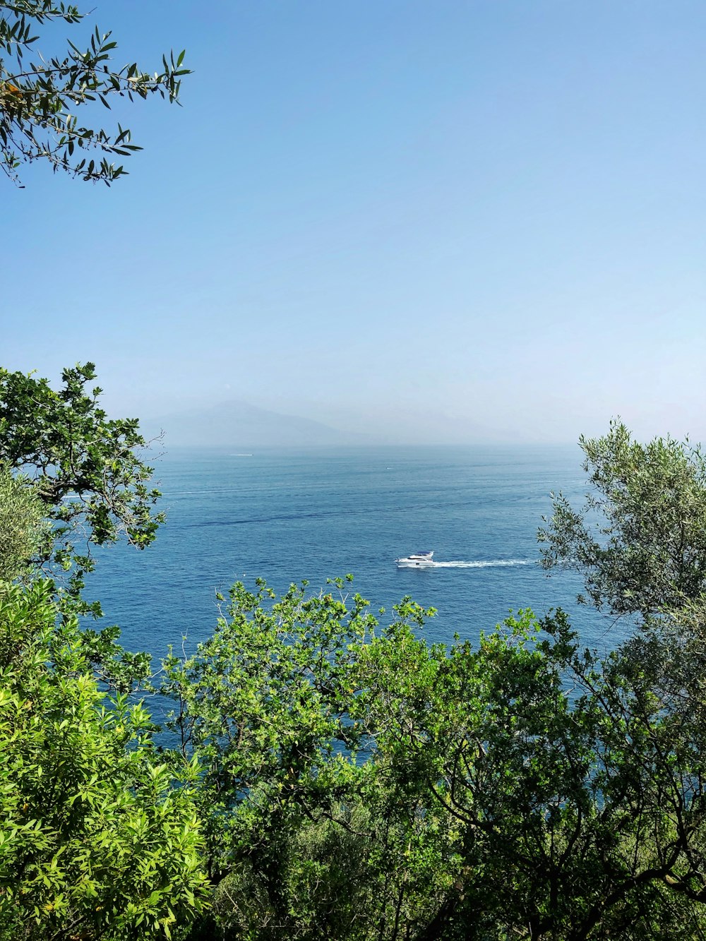 boat sailing under clear blue sky during daytime