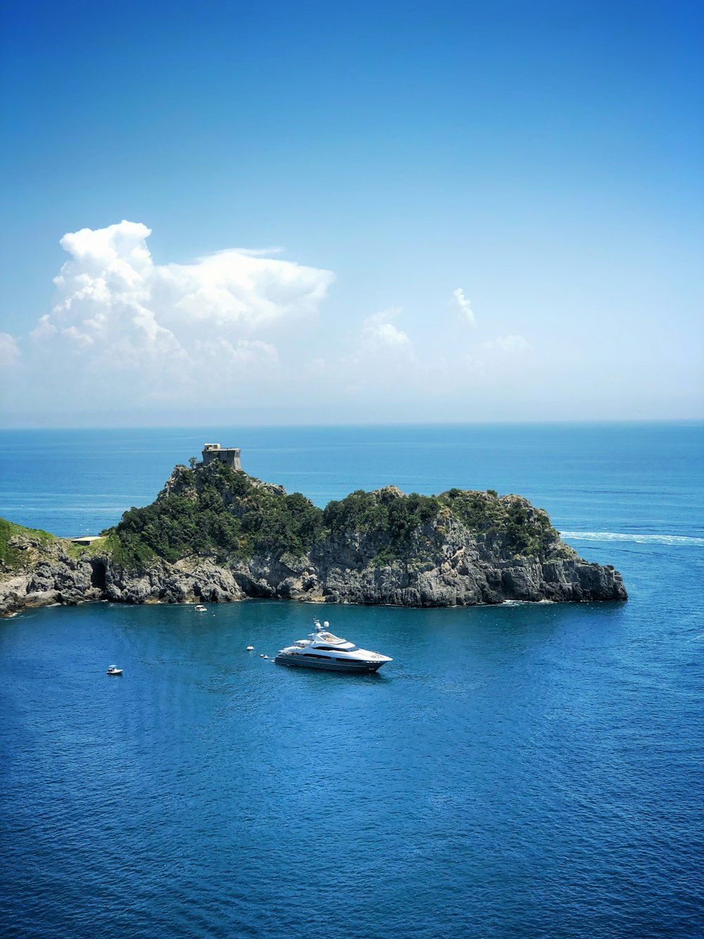 white boat beside rock formation