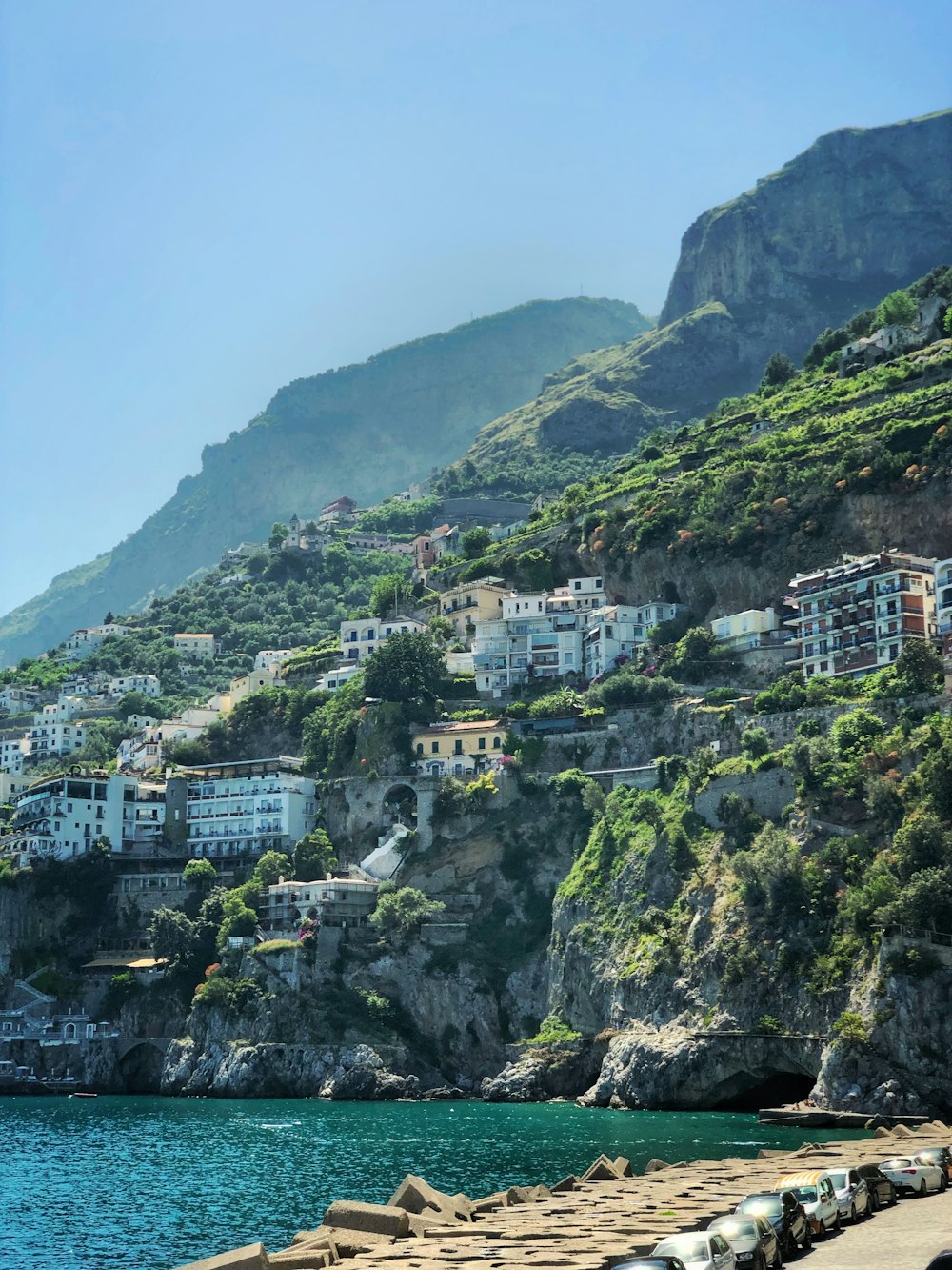 white concrete houses on sea cliff during daytime