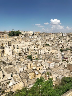 Ancient stone streets winding through a historic Chinese town under a bright blue sky.