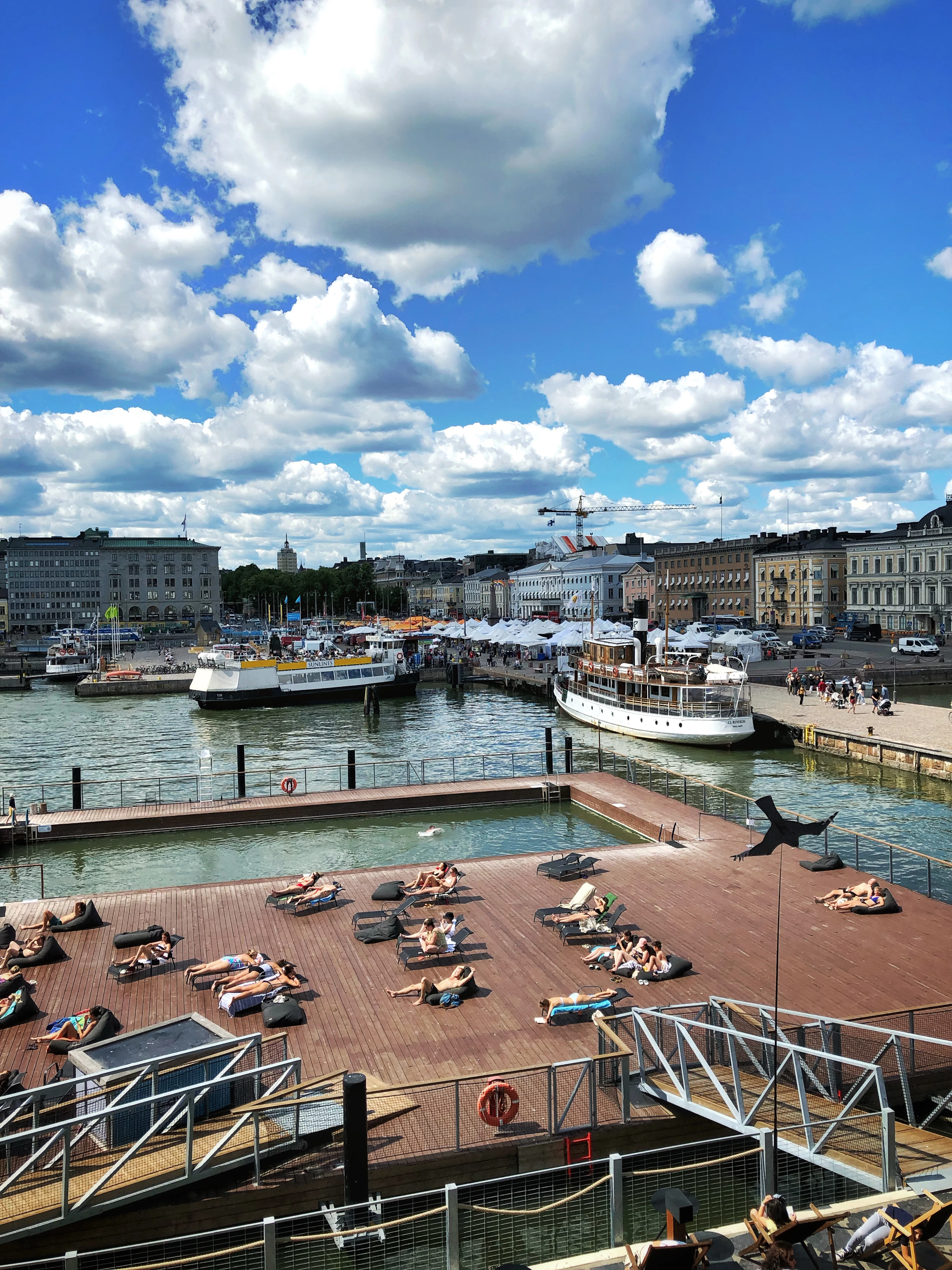 Helsinki's market harbour with old steamers moored along the quay and the city behind