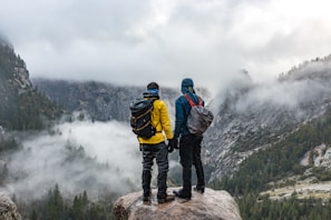 two men standing near cliff during daytime