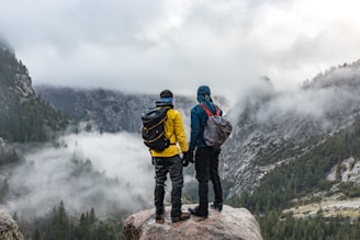two men standing near cliff during daytime