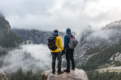 two men standing near cliff during daytime