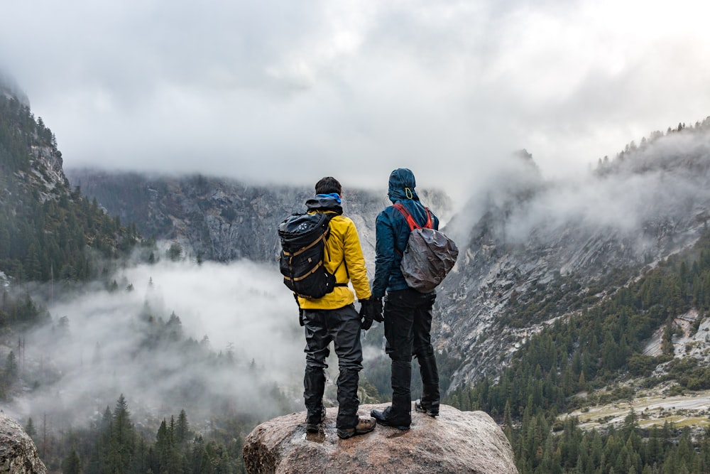 two men standing near cliff during daytime