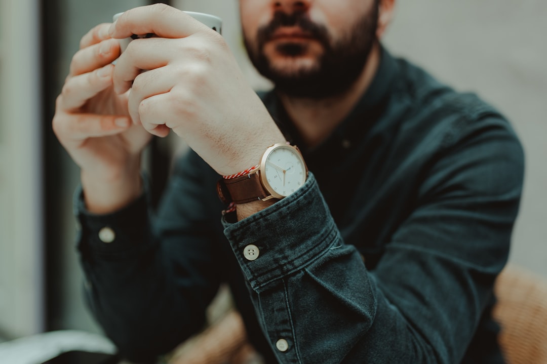 selective focus photography of sitting man wearing gray dress shirt